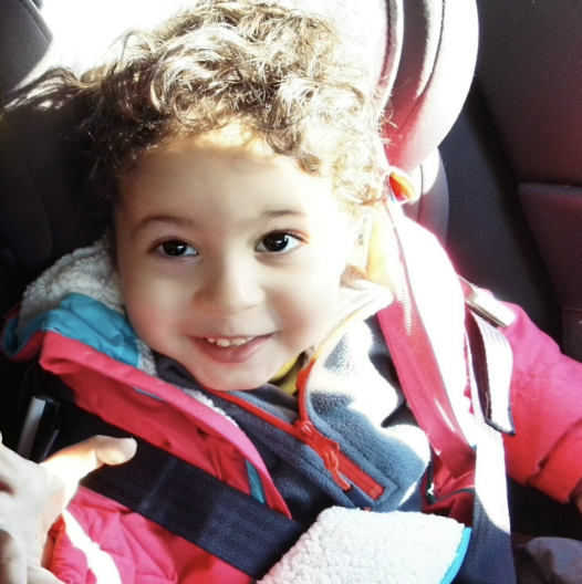 Selman smiles while sitting in car seat